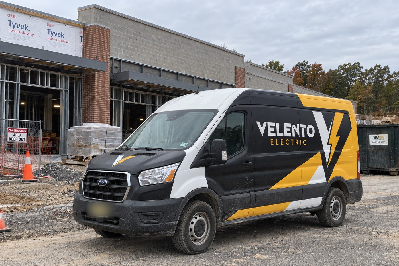 Velento Electric van with black, white and yellow wrap on a job site